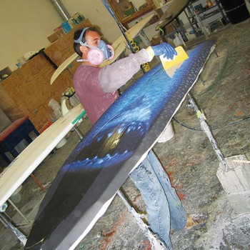 Artwork being laminated onto surfboard